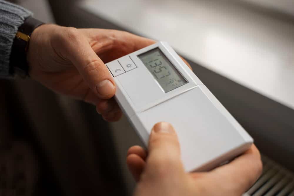 Thermostat d'ambiance dans un salon, affichant une montée progressive de la température.